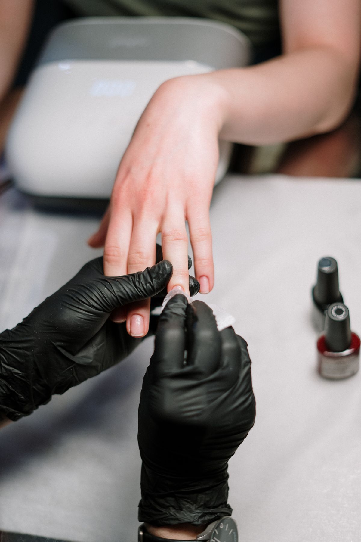 Manicure application in progress at a nail studio, illustrating the style of service at Pretty Lit Nail Bar