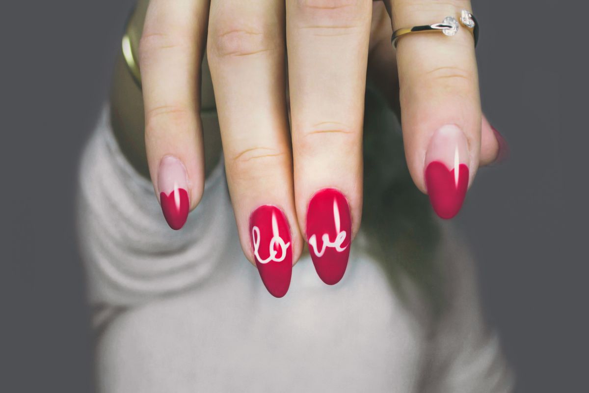 Bold red hand-painted nail art, representing custom nail art at Pretty Lit Nail Bar